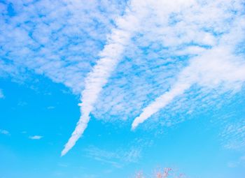 Low angle view of vapor trail against blue sky