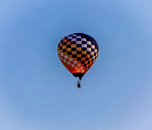 Low angle view of hot air balloon against clear blue sky