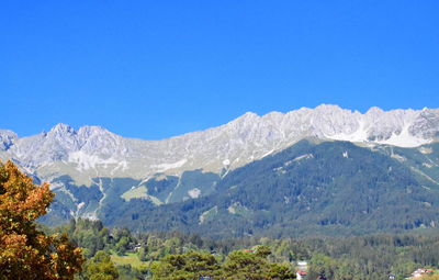 Scenic view of snowcapped mountains against clear blue sky