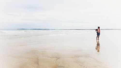 People standing on beach against sky