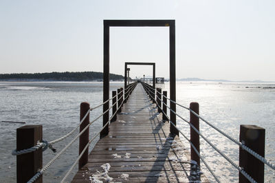 Pier over sea against clear sky