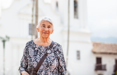 Senior adult woman at the central square in the city of guaduas. senior travel concept.