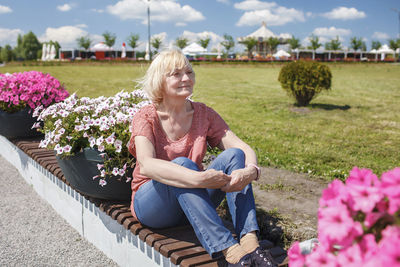 Woman sitting by flowering plants