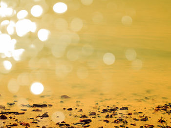 Defocused image of illuminated lights against sky