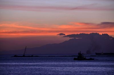 Boat sailing in sea at sunset