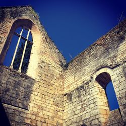 Low angle view of old building against blue sky
