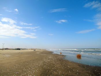 Scenic view of beach against blue sky