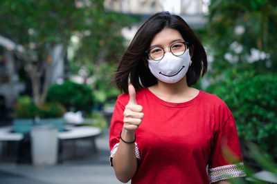 Close-up portrait of young woman wearing mask standing outdoors