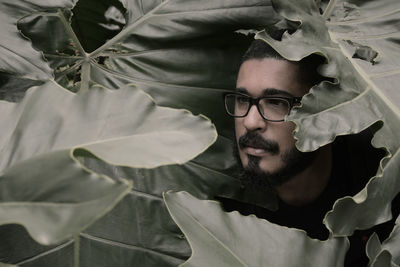 Mid adult man surrounded by leaves