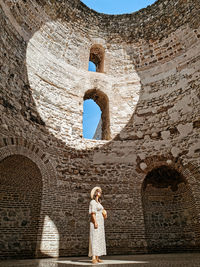 Full length of woman standing in old building