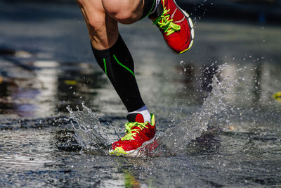 Low section of man jumping in water