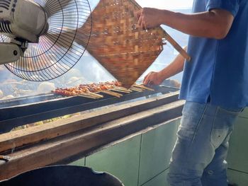 Low angle view of people on barbecue grill