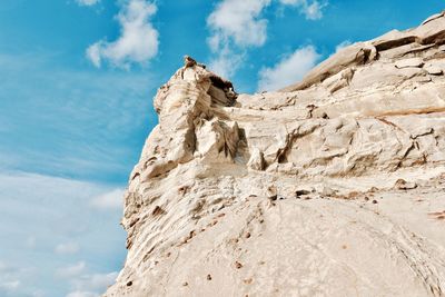 Low angle view of rocky mountain against sky