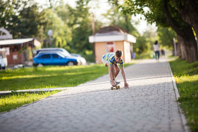 Rear view of woman walking on road