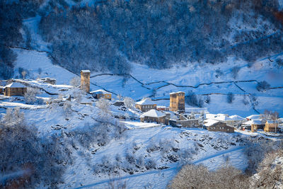Snow covered houses against blue sky