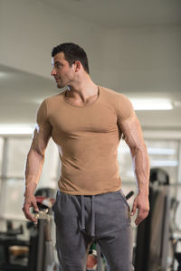 Muscular man standing in gym