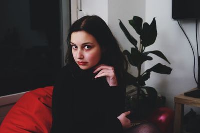 Close-up portrait of young woman sitting at home