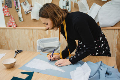 Rear view of woman working on table