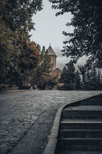 Walkway by building against sky