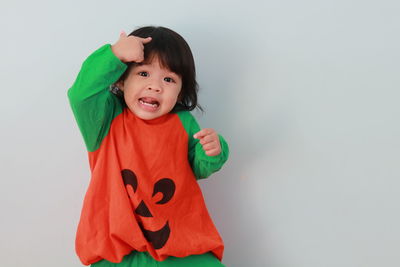 Portrait of smiling girl standing against white background