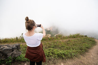 Rear view of woman photographing