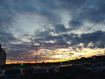 Cars on silhouette of car against sky during sunset