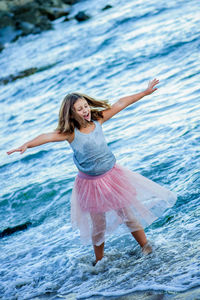 Portrait of happy girl jumping on sea