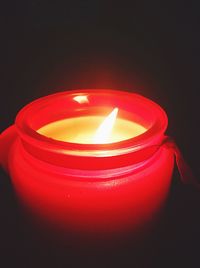 Close-up of lit candle over black background