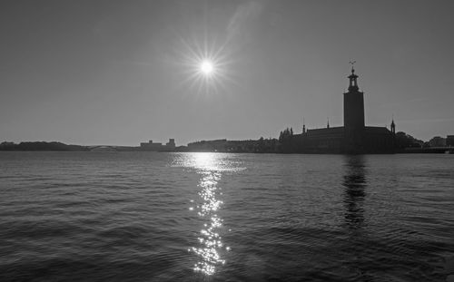 Lighthouse by sea against sky in city