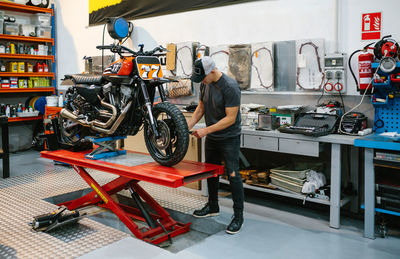 Mechanic man checking custom motorcycle over platform