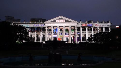 Illuminated buildings against sky at night