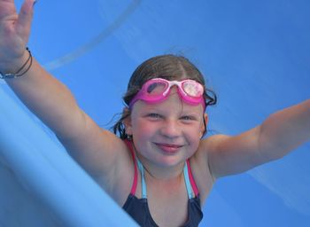 A little girl is sliding down on a flume at water park. funny children's attraction at water park. 