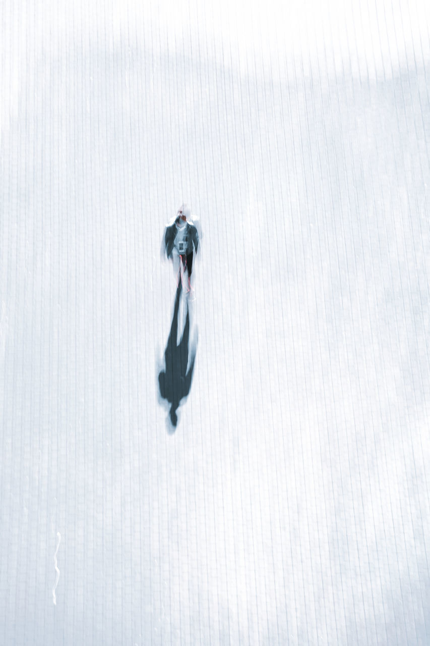 HIGH ANGLE VIEW OF PERSON WALKING ON SNOW