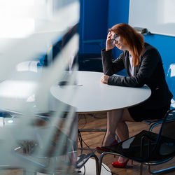 Rear view of woman using mobile phone in cafe