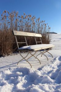 Snow on field against clear sky during winter