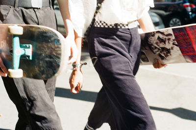 Rear view of woman holding umbrella on street