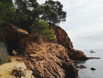 Rock formation on beach against sky