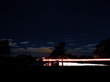 Silhouette trees against sky at night