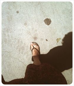 Low section of woman standing on tiled floor