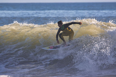 Man surfing on sea shore