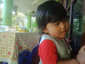 Portrait of cute boy looking through window