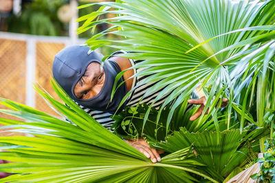 Young man lying down on palm leaves