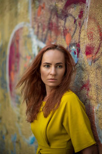 Woman standing by graffiti wall