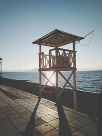 Lifeguard hut by sea against clear sky