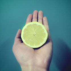 Close-up of hand holding apple against white background