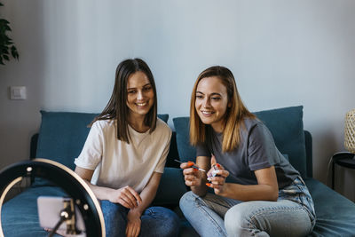 Portrait of a smiling young woman sitting on sofa