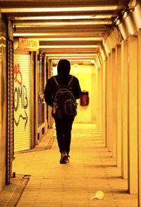 Rear view of man walking in tunnel