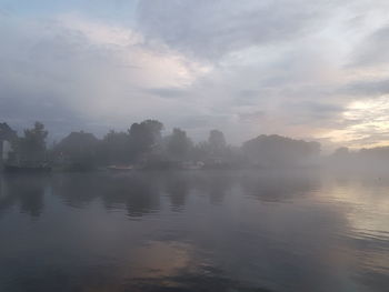 Scenic view of lake against sky at sunset