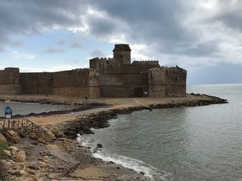 Historic building by sea against sky