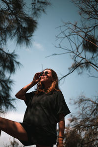 Low angle view of woman standing against sky